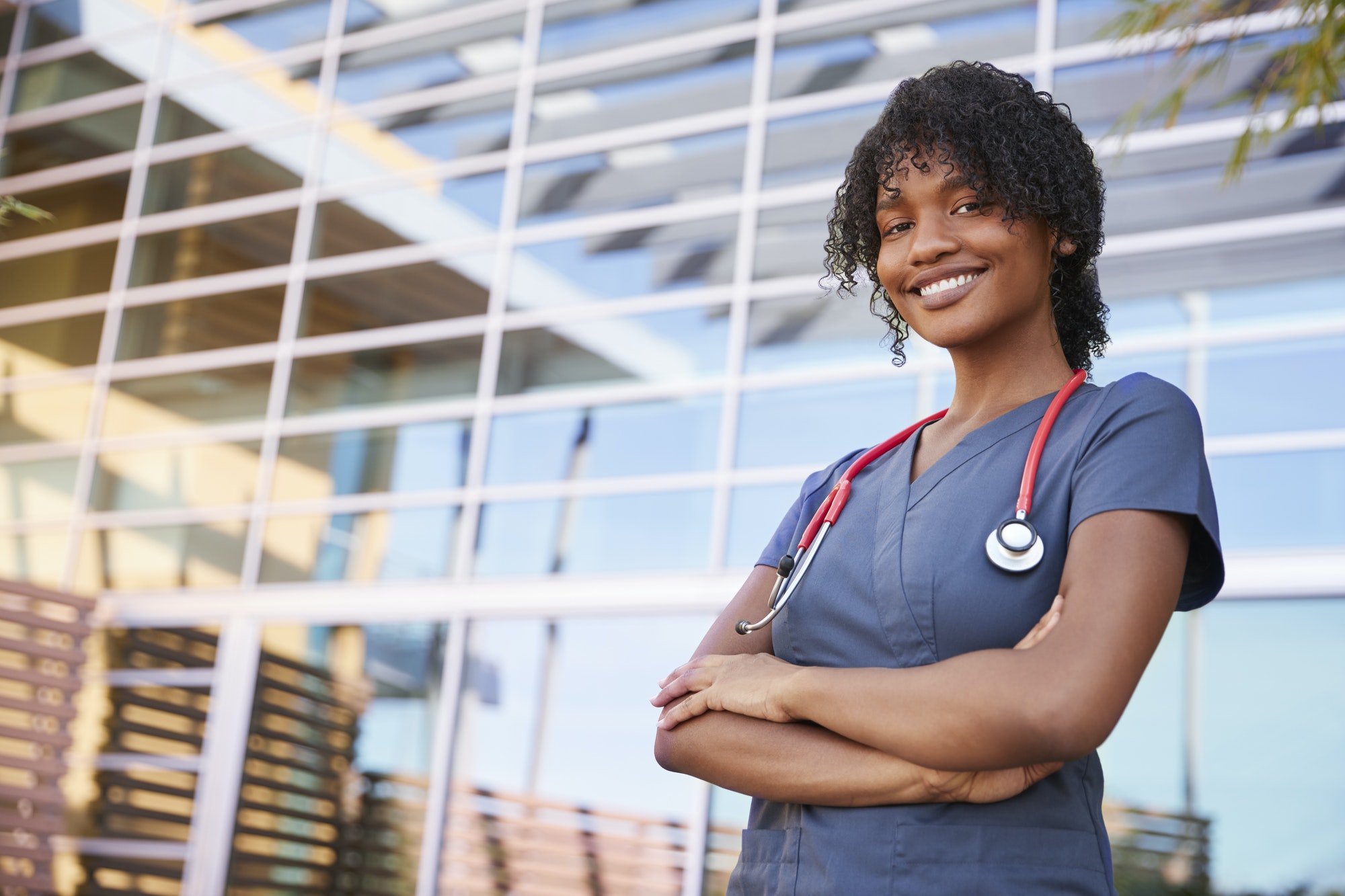 Portrait of smiling black female healthcare worker outdoors